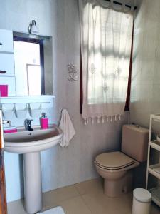 Un baño con lavabo, inodoro y espejo. en Riegos de Lino, en Barlovento 22 fotos más