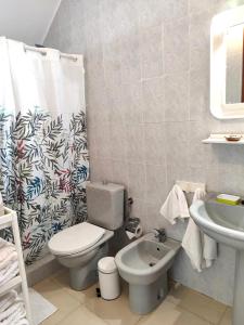 Un baño con inodoro, lavabo y cortina de ducha. en Riegos de Lino, en Barlovento