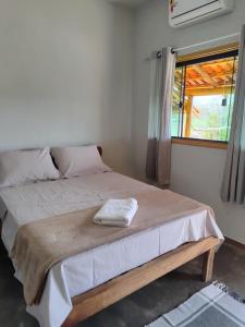 a bedroom with a bed with a towel on it at Chalésforquilha in Delfinópolis