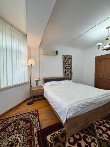 a bedroom with a large bed and a window at Alay-Art Hotel in Osh