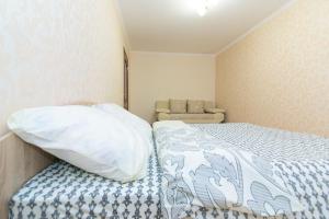 Un dormitorio con una cama con almohada y un sofá. en Apart-Hotel, en Sumy