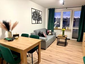 un soggiorno con un tavolo e un divano di Nowoczesne, jasne, trzypokojowe mieszkanie-pełne wyposażenie, Wi-fi, parking a Szczecinek Altre 13 foto