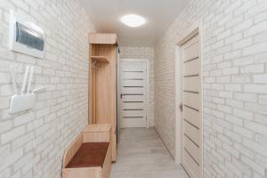 bagno con panca e parete di mattoni bianchi di center apartments a Sumy