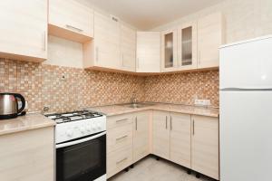 una cucina con mobili bianchi e un frigorifero bianco di center apartments a Sumy