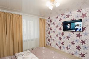 una stanza con una televisione su una parete con fiori di center apartments a Sumy