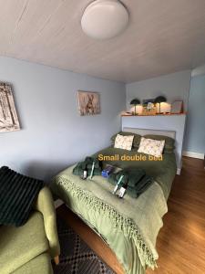 a small double bed in a room with a couch at Julara in Deganwy