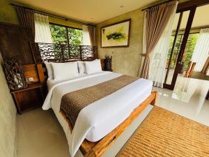 a bedroom with a large white bed and windows at ELForest ex Karang Dukuh Villa, Ubud in Payangan +69 photos