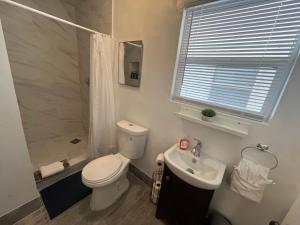 a bathroom with a toilet and a sink and a shower at Cozy Weekend Retreat! in Wofford Heights +16 photos