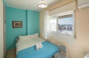 Habitación azul con cama y ventana en Breezot Yam, en Nahariyya