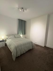 a white bedroom with a bed and a window at Jerryinn Rooms in London +10 photos