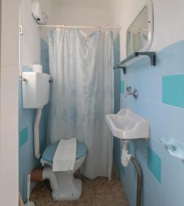 a blue bathroom with a toilet and a sink at Breezot Yam in Nahariyya