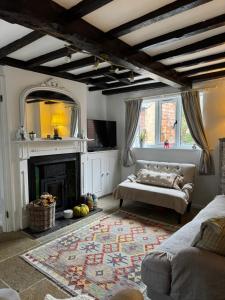 a living room with a couch and a fireplace at Pear Tree Cottage in the Cotswolds in Mickleton