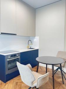a kitchen with white cabinets and a table and chairs at Super modern, in the very center of the city, mega center, wow, shocking prices in Almaty