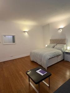 a bedroom with a bed and a table in it at Jerryinn Rooms in London