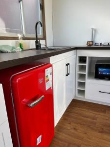 einen roten Kühlschrank in einer Küche mit Spüle in der Unterkunft Casa en la playa la Ballena in Guaquen