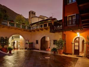 an empty courtyard of a building with a balcony at Casa alla Fontana in Serravalle allʼAdige