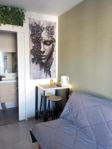 a bedroom with a bed and a table with a head on the wall at Studio in Moussac