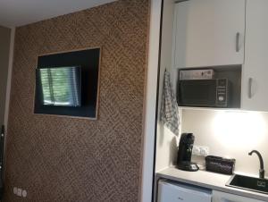 a kitchen with a wall with a window and a microwave at Studio in Moussac