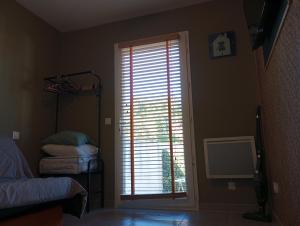 a bedroom with a window with blinds on a door at Studio in Moussac