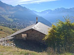 ein kleines Gebäude auf einem Hügel mit Bergen im Hintergrund in der Unterkunft Le Raidillon Verbier in Verbier + 6 Fotos