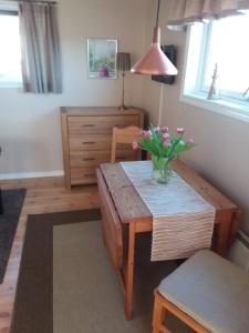 a room with a table with a vase of flowers on it at Furusol Borgholm in Borgholm