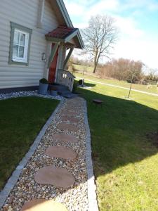 a backyard with a stone walkway next to a house at Furusol Borgholm in Borgholm