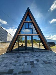 una casa triangular con ventanas en la parte superior de un tejado en A Frame house Slavuljica, en Vlašić