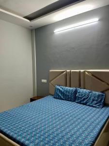 a bedroom with a bed with blue sheets at Private Room in Peaceful Flat Attached Washroom in Kharar +4 photos