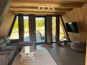 a living room with a couch and a tv at A Frame house Slavuljica in Vlasic