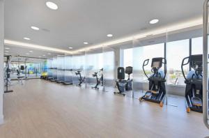 a gym with treadmills and exercise bikes in a room at Central 1BR Apartment Assembly Square Pool Gym Parking Sleep 5 in Winter Hill