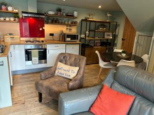 a living room with a couch and a kitchen at Beach hut seaside cottage in Sheringham