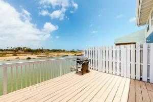 ポートイザベルにあるCozy Waterfront with Deckの白いフェンスとグリル付きのバルコニー