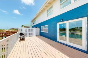 ポートイザベルにあるCozy Waterfront with Deckの青と白の建物のある大きなデッキ