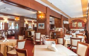 un ristorante con tavoli e sedie in una stanza di Elina Hotel a Pamporovo