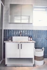 a bathroom with a white sink and a mirror at Palm Villa Beachfront Accomodation in Hentiesbaai +65 photos