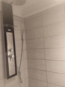 a bathroom with a shower with a phone on the wall at Gîte des pins 1 et 2 personnes in Saint-Martin-au-Bosc +4 photos
