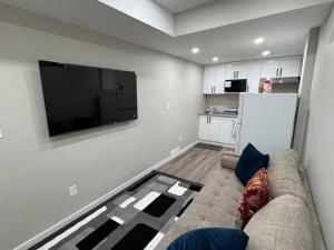 a living room with a couch and a flat screen tv at Oxnard Villa in Winnipeg +17 photos