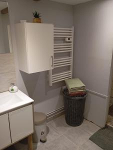 a kitchen with a white cabinet and a trash can at Gîte des pins 1 et 2 personnes in Saint-Martin-au-Bosc