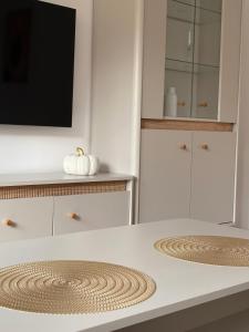 a white kitchen with a table with a tv on it at 10 METRÓW OD ZAMKU Malbork in Malbork