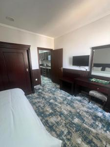 a hotel room with a bed and a desk at شركة نيروز ان للشقق المخدومه in Jeddah