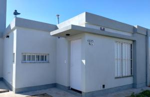 a white house with a garage at Casa de 2 dormitorios in Las Varillas