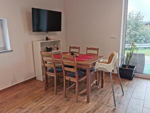 a dining room table with chairs and a television at Apartma Lipa in Veliki Gaber +19 photos