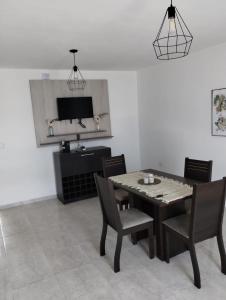 a dining room with a table and chairs and a television at Casa de 2 dormitorios in Las Varillas