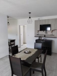 a dining room with a black table and chairs at Casa de 2 dormitorios in Las Varillas