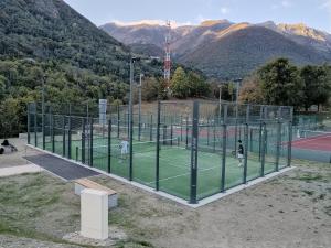 a group of people playing tennis on a tennis court at Le Nid Des Marmottes in Cauterets
