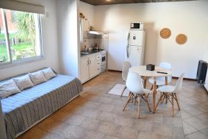 a kitchen with a bed and a table and chairs at Tangerina Apart Hotel - Villa Gesell in Villa Gesell