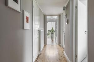 an empty hallway with a potted plant on the wall at Rum i modern stor & ljus villa nära centrum in Växjö
