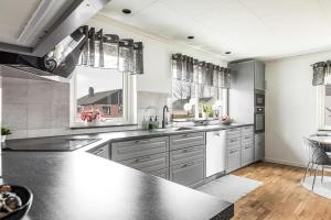 a large kitchen with a sink and a counter at Rum i modern stor & ljus villa nära centrum in Växjö