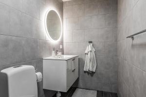 a bathroom with a sink and a mirror at Rum i modern stor & ljus villa nära centrum in Växjö