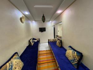 une petite pièce avec un canapé bleu et des oreillers dans l'établissement Sunset house, à Taghazout